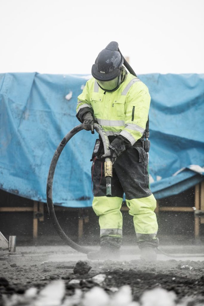 Construction worker operating heavy machinery at a building site, ensuring safety and precision.